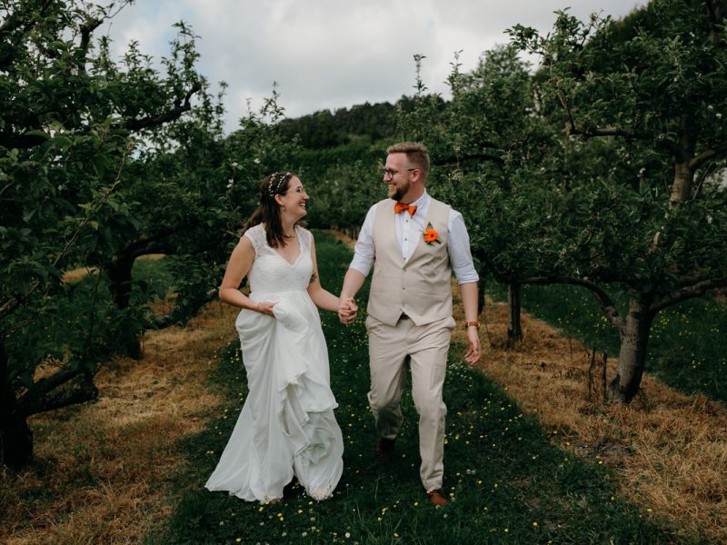 coatesville settlers hall wedding auckland bride and groom running in Windmill Orchards by sarah weber photography