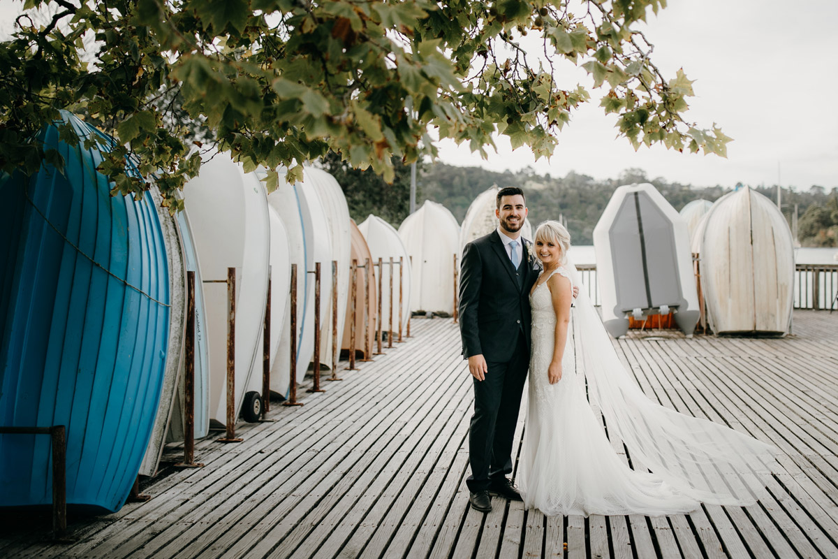 Bride and Groom posing at Herald Island Wharf in Whenuapai, Auckland photo by Sarah Weber Photography