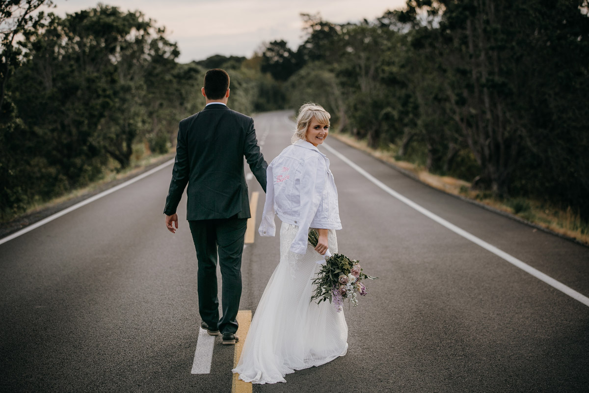 Bride and Groom walking on Herald Island Road in Whenuapai, Auckland photo by Sarah Weber Photography