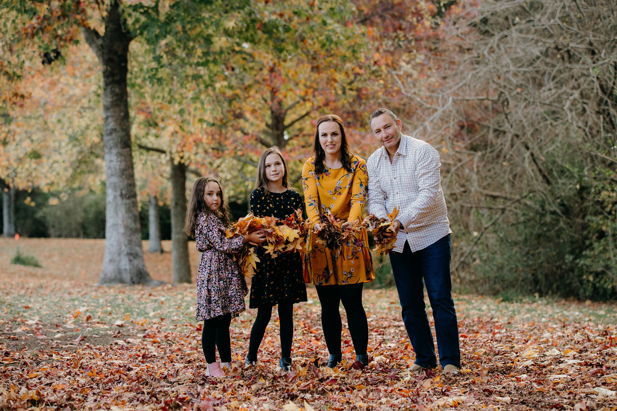 family holding leaves in autumn lifestyle portrait photoshoot session in west auckland. Photos by sarah weber photography
