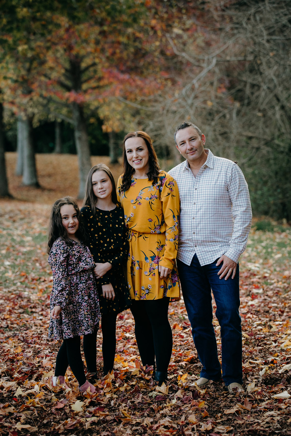 family posing together in autumn lifestyle mini portrait photoshoot session in west auckland. Photos by sarah weber photography