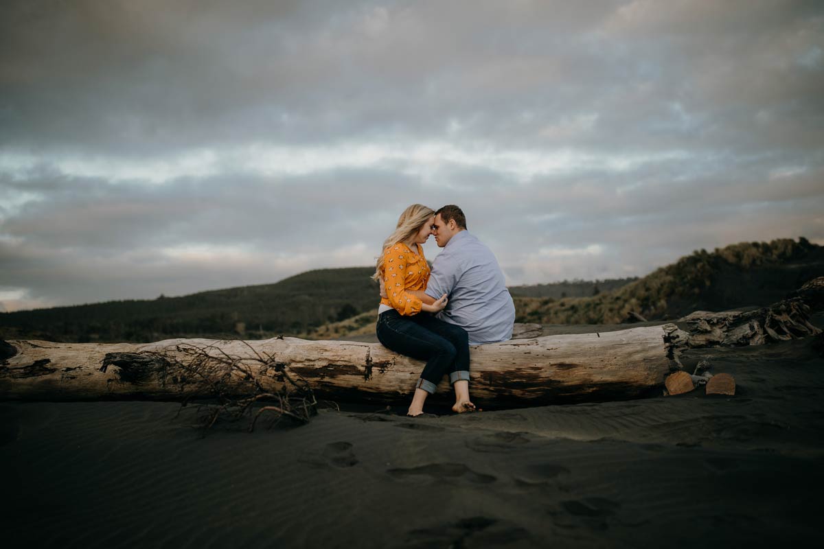 couple portrait muriwai beach auckland new zealand during a golden light evening lifestyle engagment pre-wedding photoshoot session by sarah weber photography