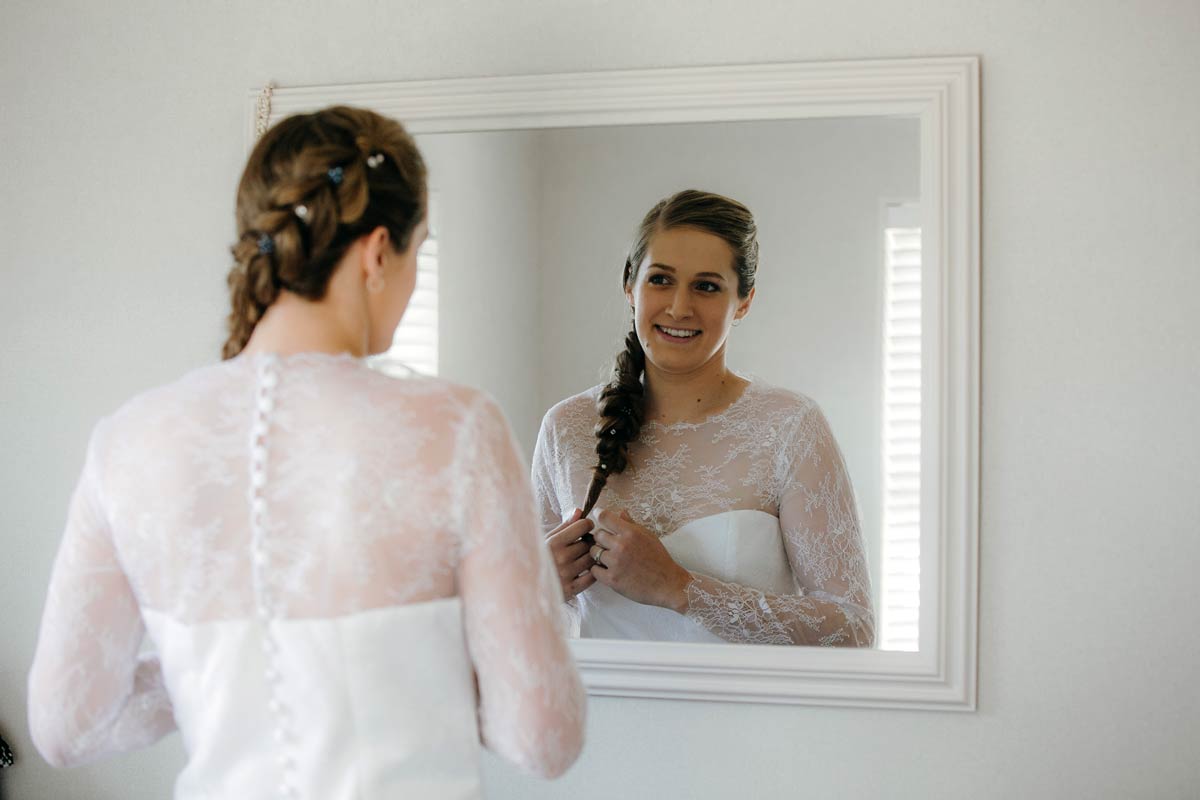 Bride checking hair in mirror ready for bridgewater country estate wedding in Kaukapakapa, Auckland photo by sarah weber photography